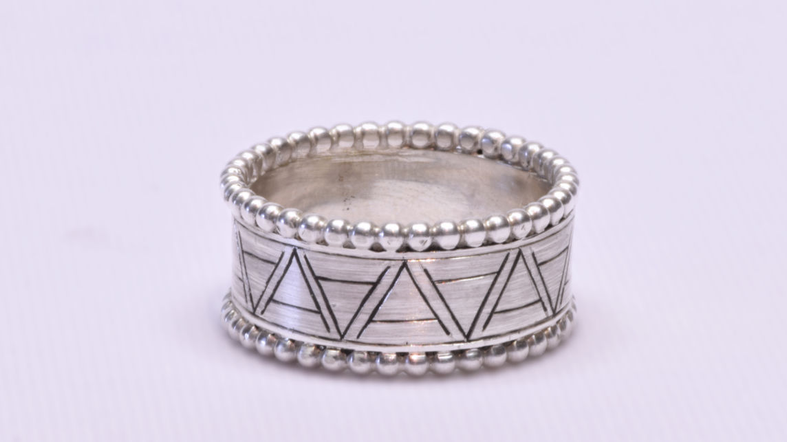 Bague en or blanc gravée sur mesure avec une frise de lettres stylisées