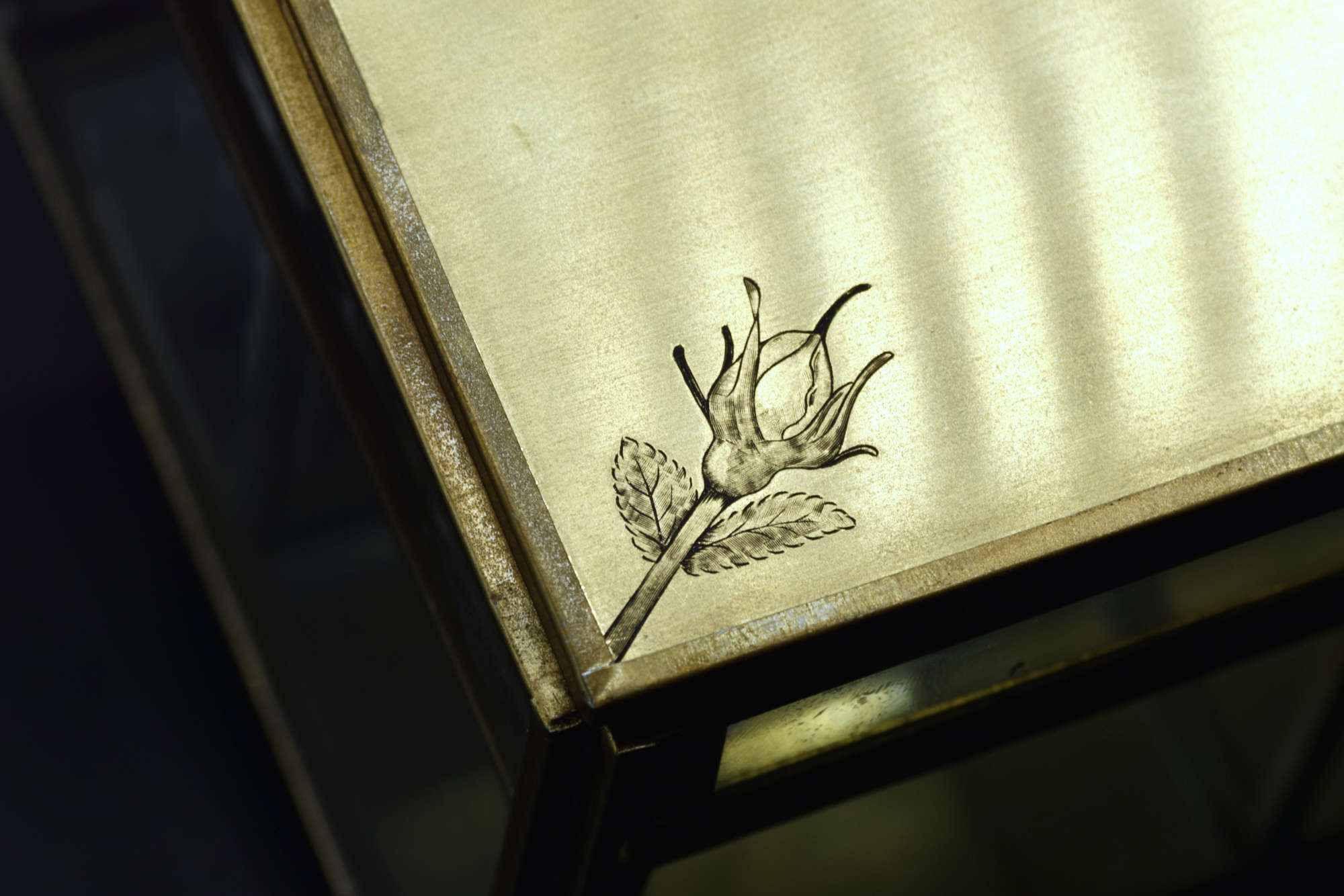 Détail d'une fleur gravée à la main sur laiton