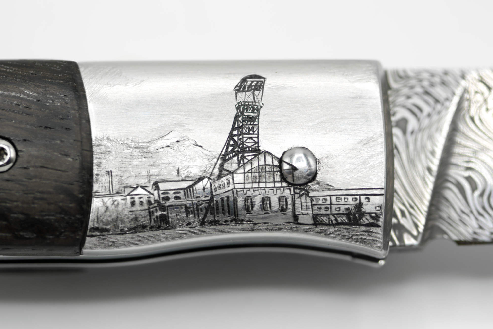 Gros plan sur gravure sur mesure : le Puits Couriot (Saint-Étienne) sur mitre de couteau en inox