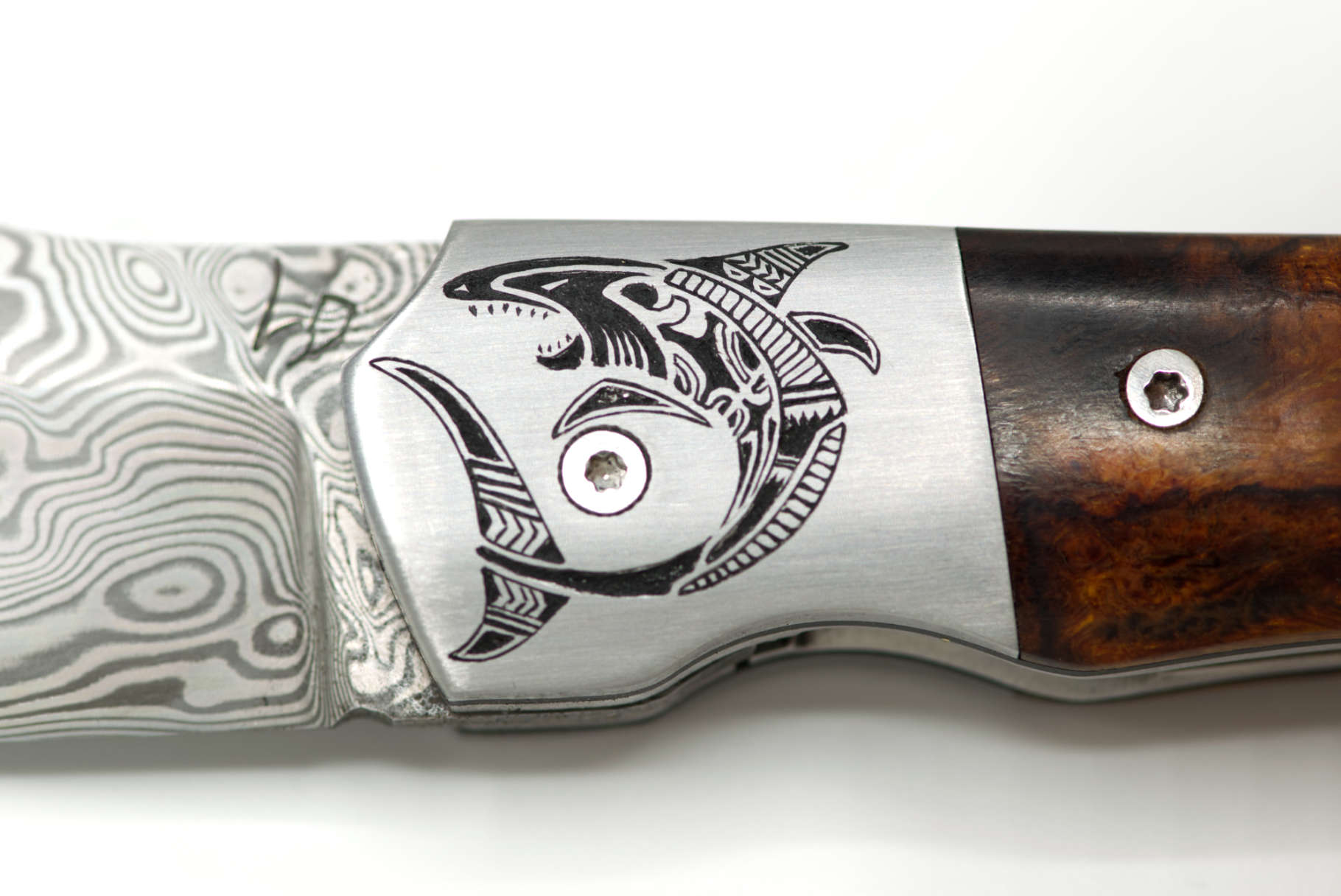 Gros plan recto : Requin stylisé (motif Maoris) gravé en taille douce sur mitre de couteau inox
