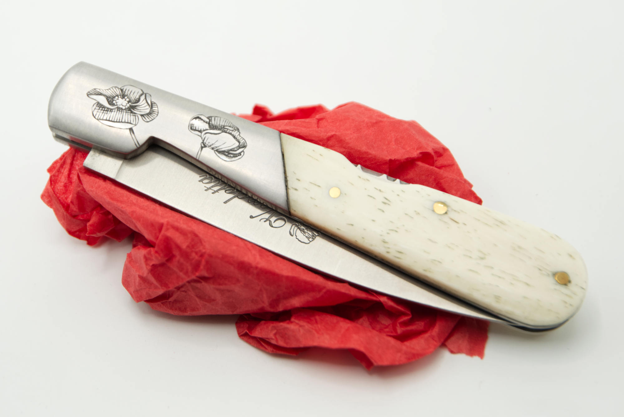 Gros plan : détail de la gravure du Coquelicot sur mitre de couteau inox