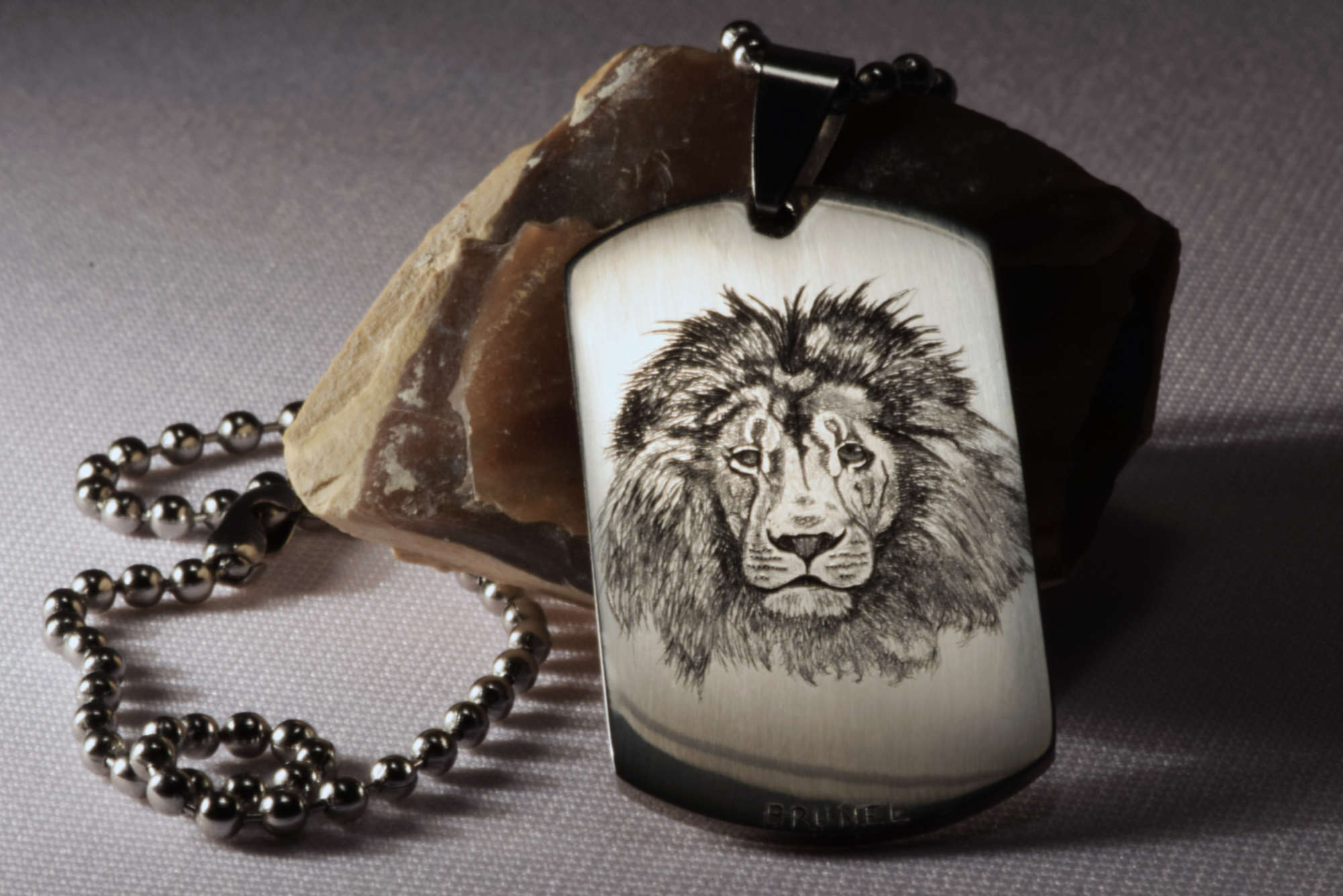 Tête de lion en taille douce sur un pendentif en acier : motif puissant choisi sur mesure